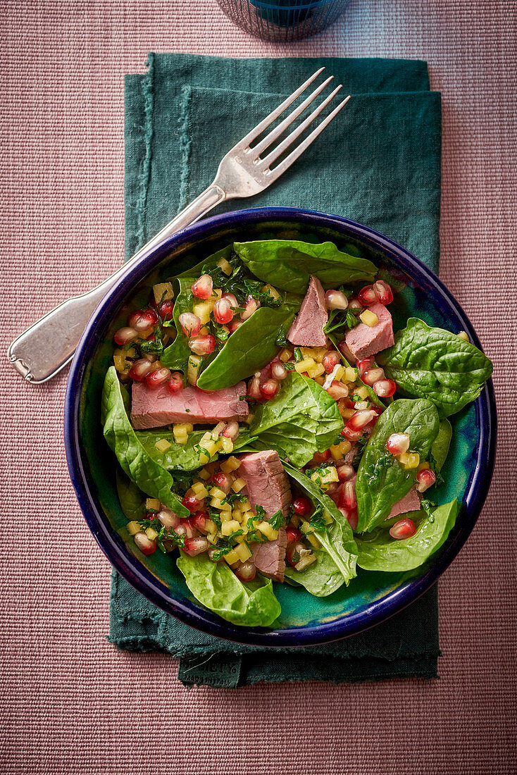 Roast beef with spinach and pomegranate seeds