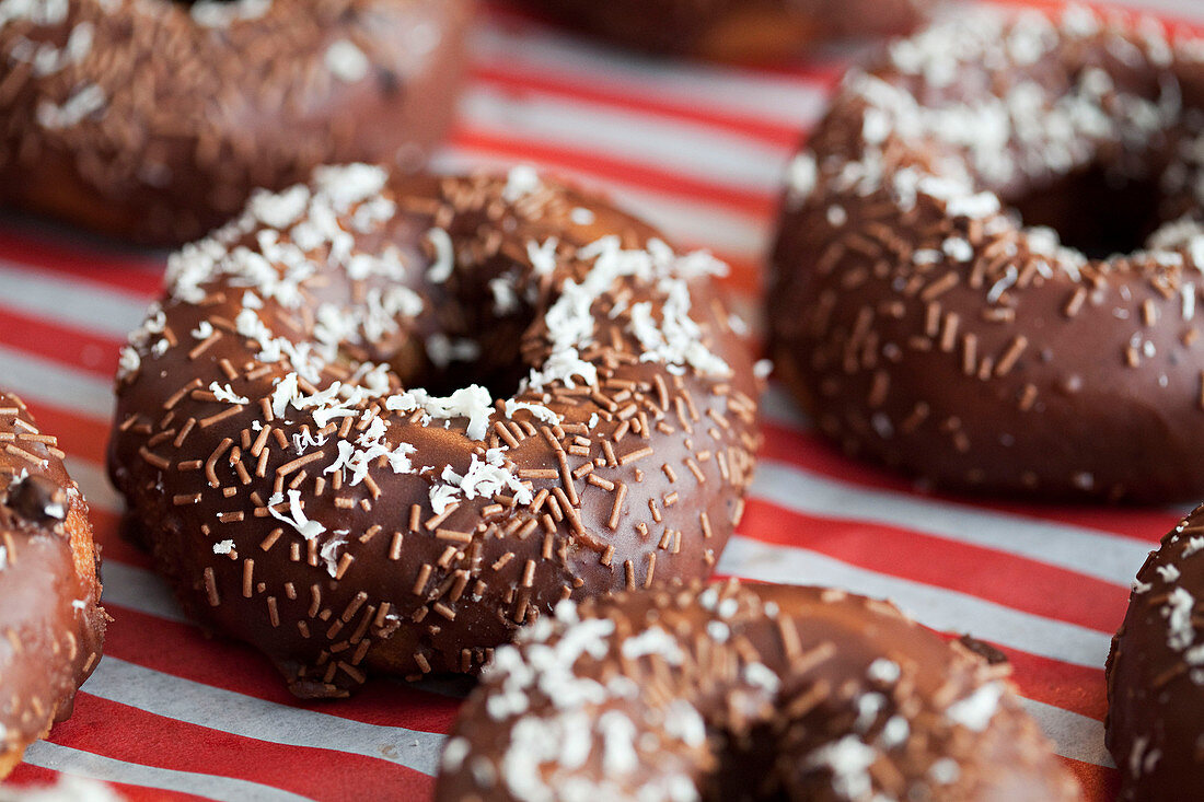 Donuts mit Schokoladenglasur, Schokostreuseln und Kokosraspeln