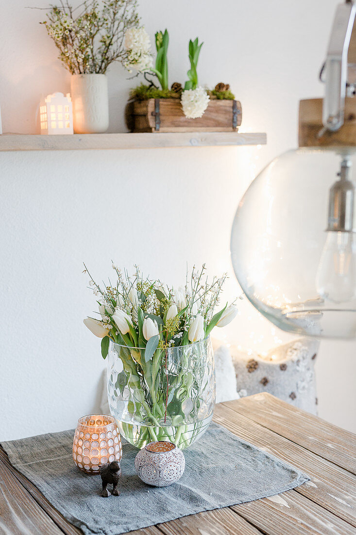 Tulpen und weißer Ginster im Glasgefäß