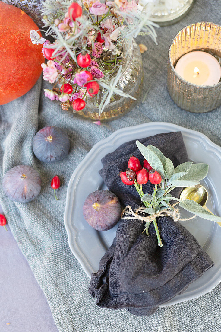 Autumnal arrangement with rose hips and figs on table
