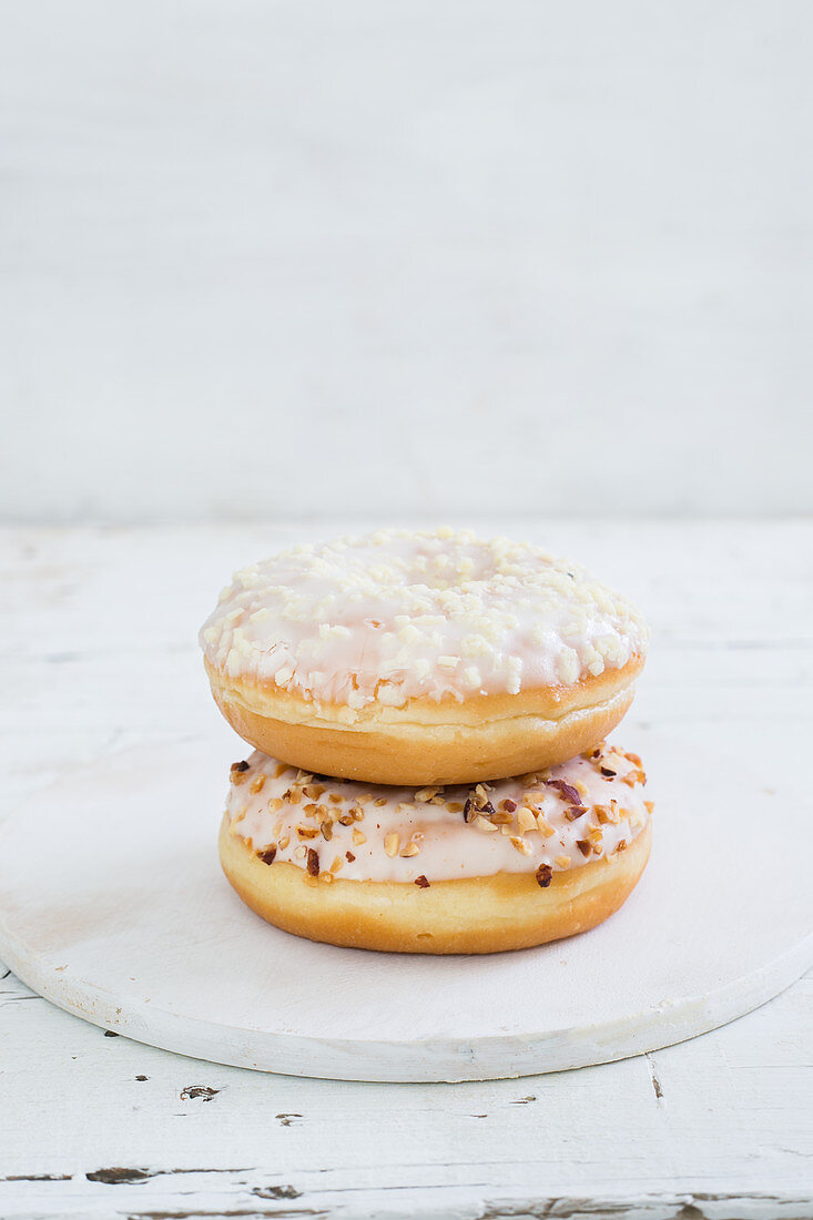 Two iced doughnuts, piled