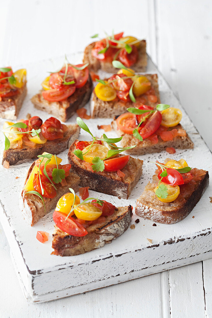 Bruschetta laid out on a white wooden board