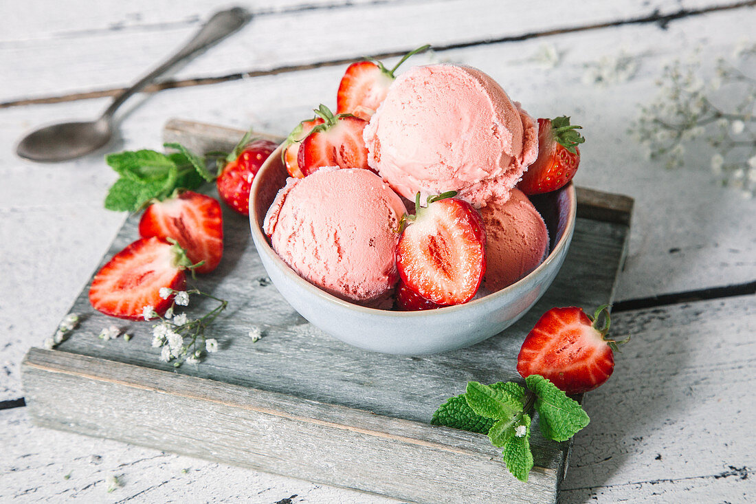 Erdbeer-Joghurteis mit frischen Erdbeeren im Schälchen