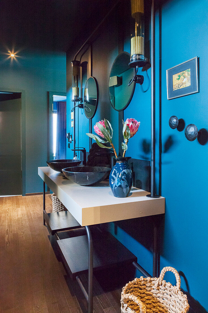 Washstand with twin sinks against blue wall in hall