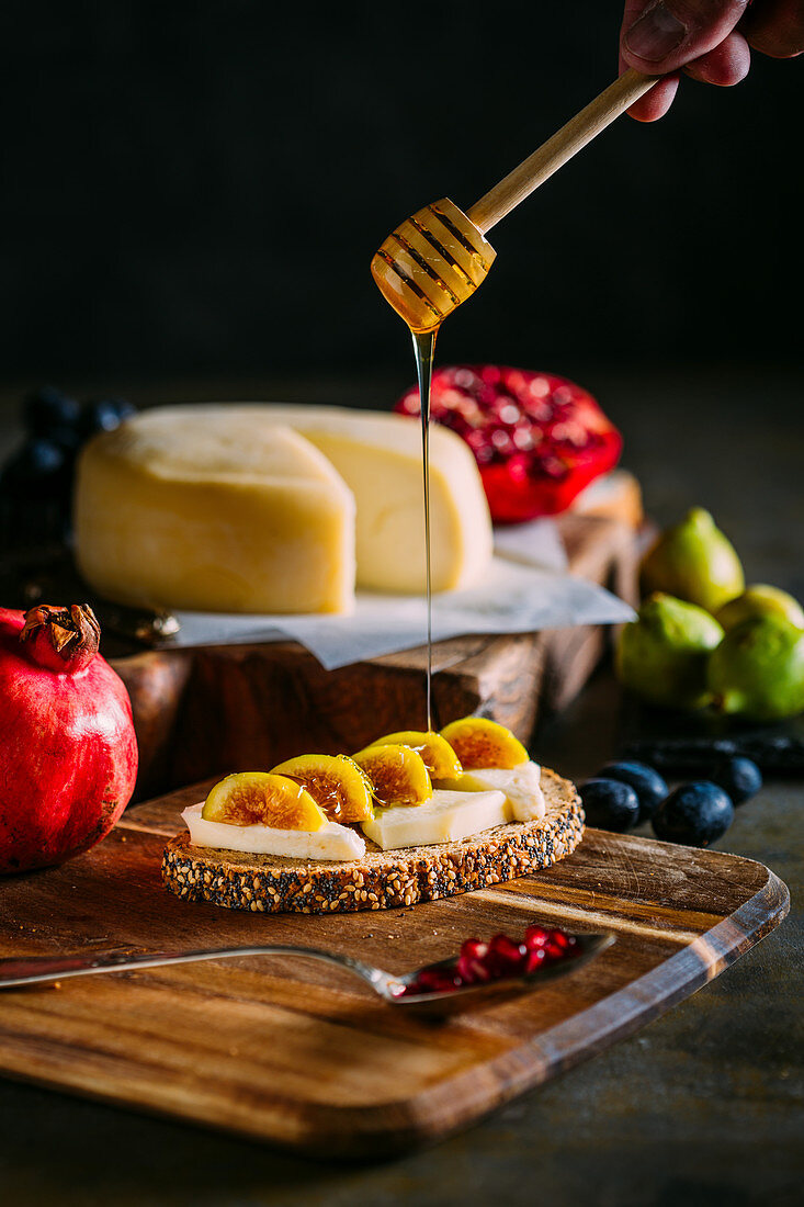 Toast with cheese, figs and honey in a wooden table