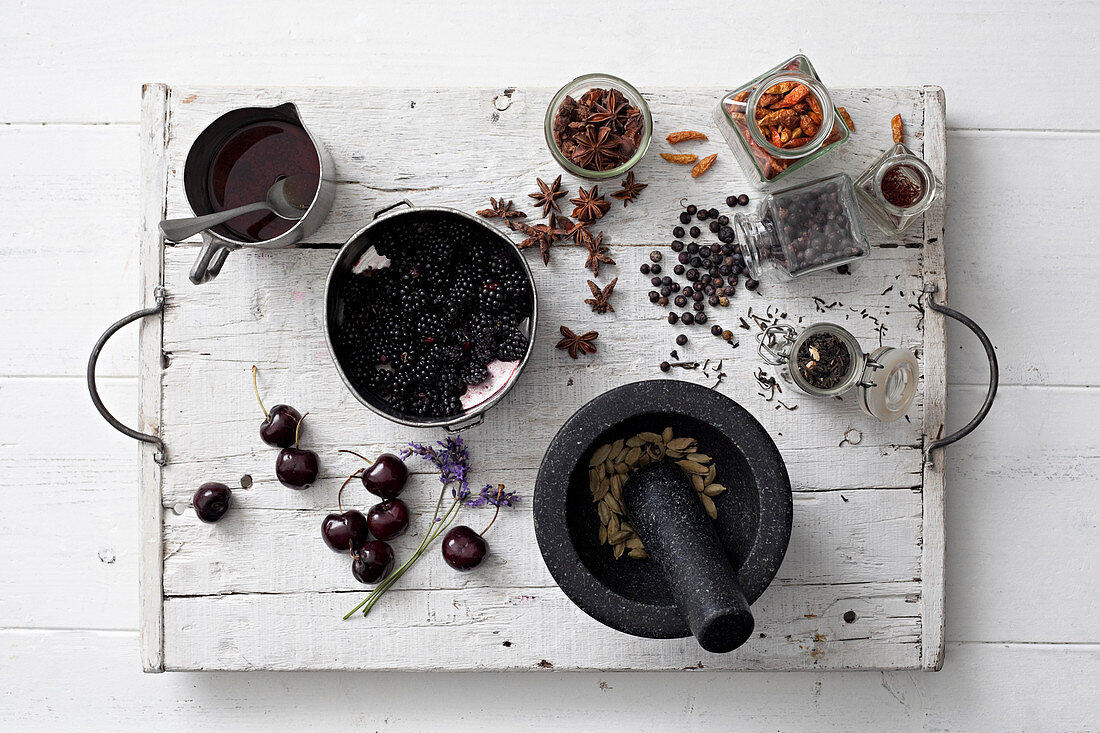 Verschiedene Gewürze, Brombeeren und Kirschen auf Vintage-Tablett