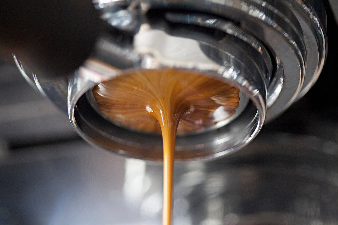 Kaffee fliesst aus einer Espressomaschine