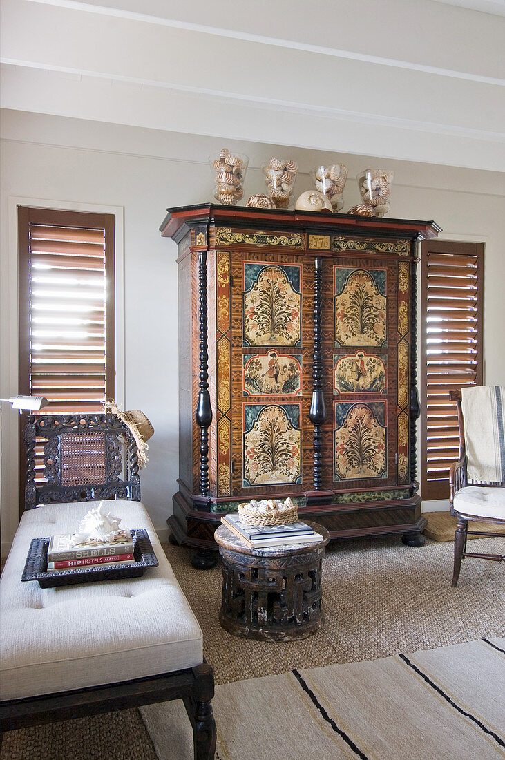 Antique painted cabinet flanked by two louvre windows