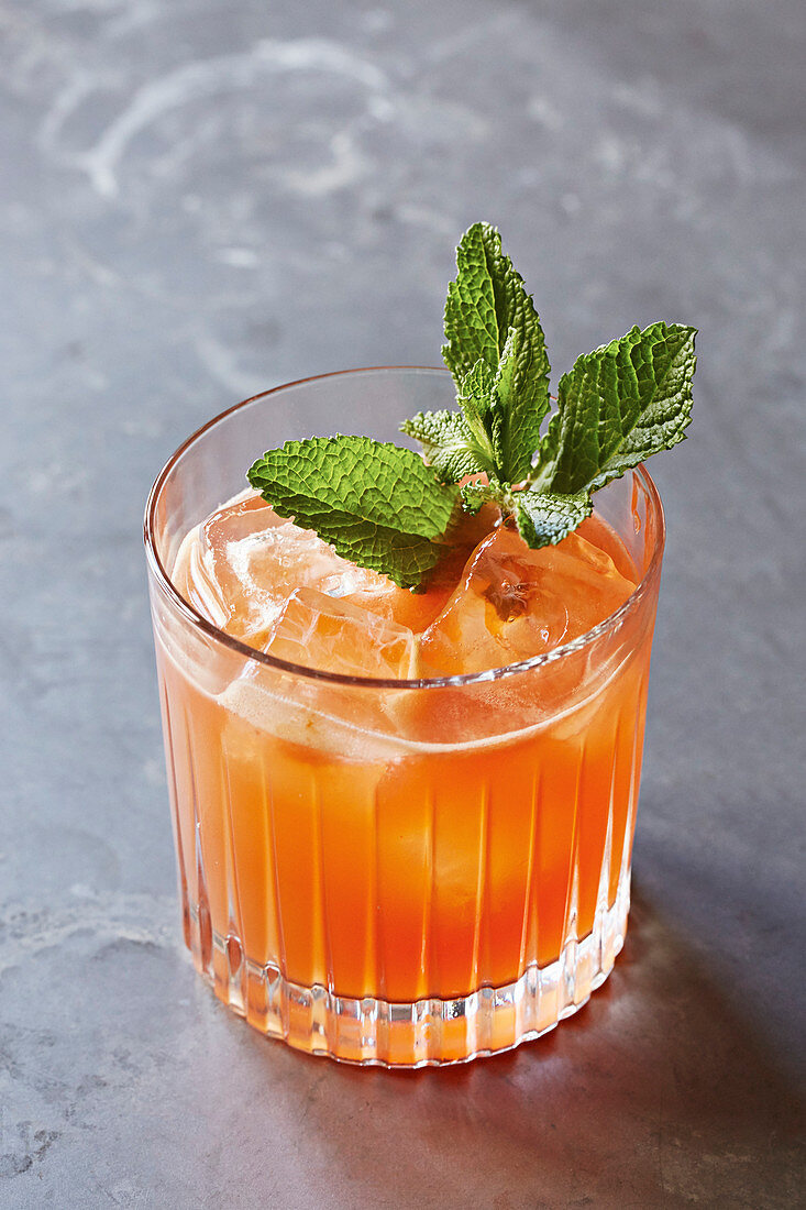 Oranger Cocktail mit Minzblättern