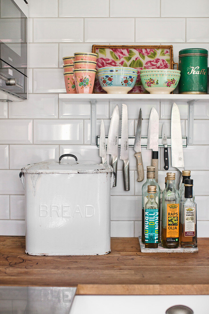 Old bread bin, magnetic knife rack and vintage crockery on shelf