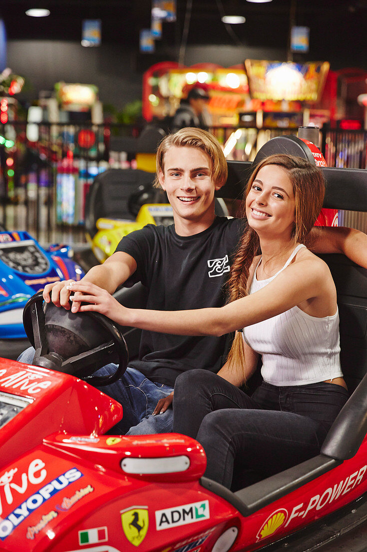 A teenage couple sitting in a dodgem