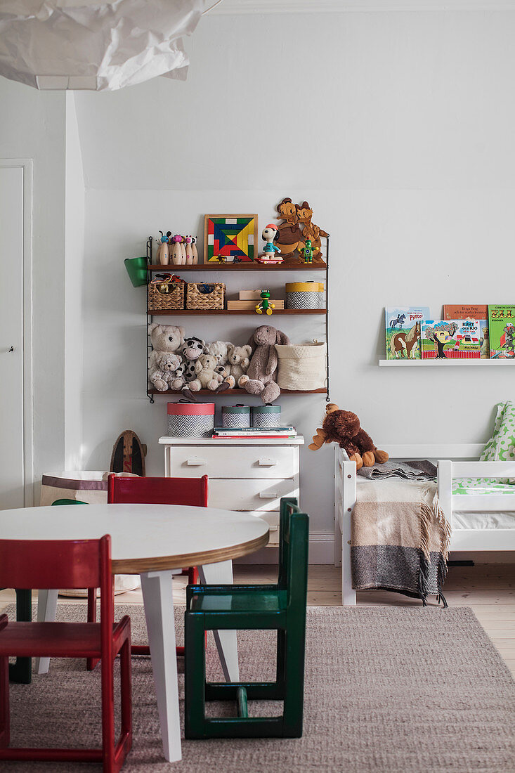 Table, chairs, cabinet and toys on shelves in child's bedroom