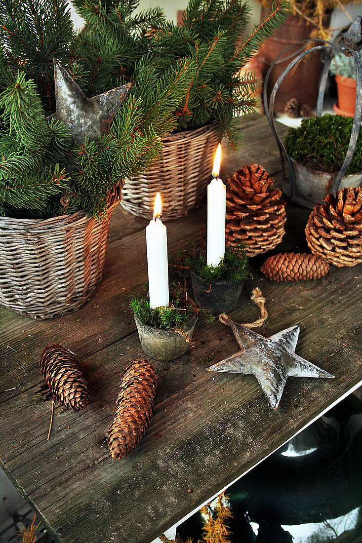Weihnachtsdekoration mit Tannenzweigen, Zapfen und Kerzen
