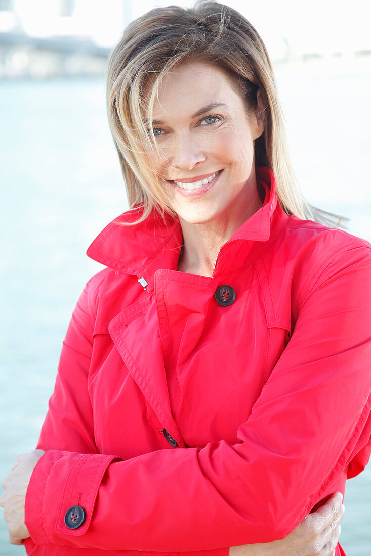 A blonde woman wearing a red trench coat