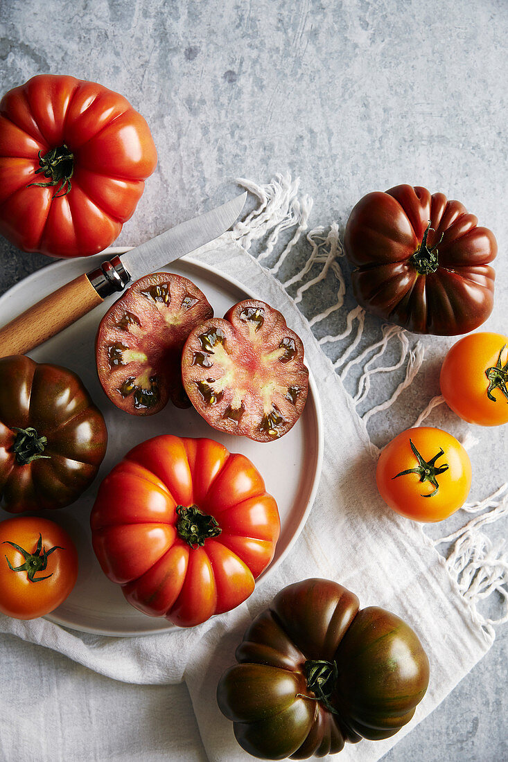 Verschiedene Heirloom Tomaten, ganz und halbiert (Aufsicht)