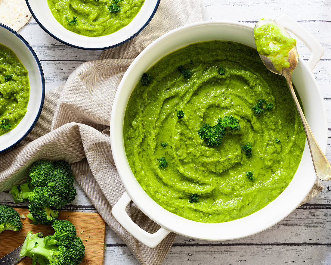 Broccolisuppe in Topf und Emailleschälchen (Aufsicht)