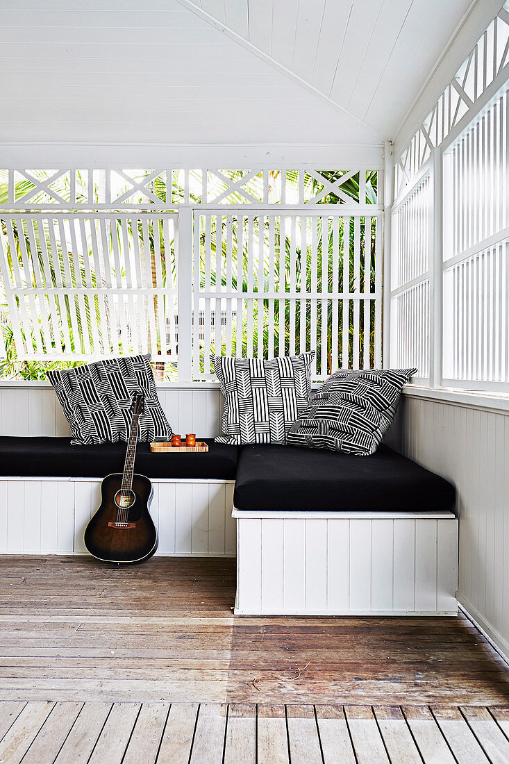 Guitar on daybed with black pad and pillow