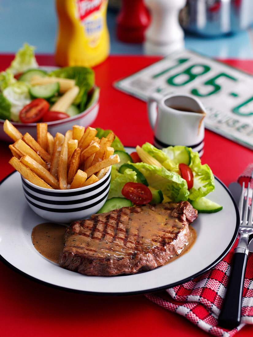 Beef steak with chips and salad in a diner