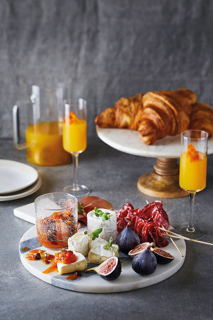 Continental Breakfast mit Käse, Feigen, Salami, Parmaschinken, Orangenmarmelade und Croissants