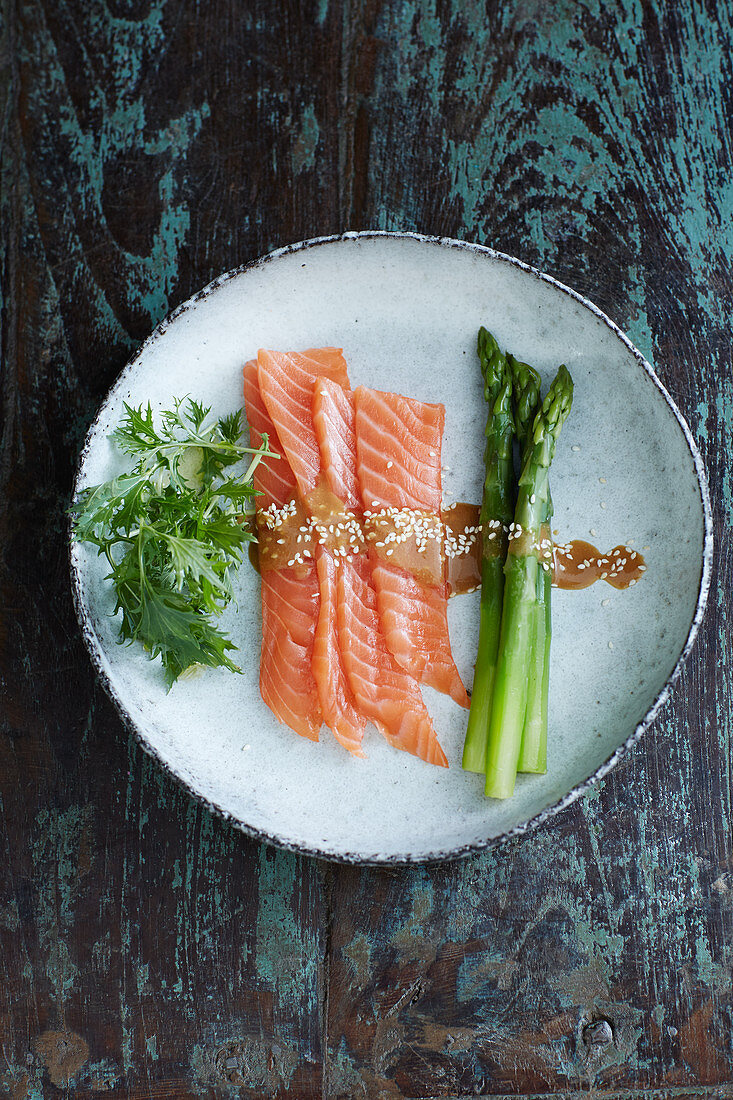 Salmon sashimi with miso sauce, green asparagus and mizuna lettuce