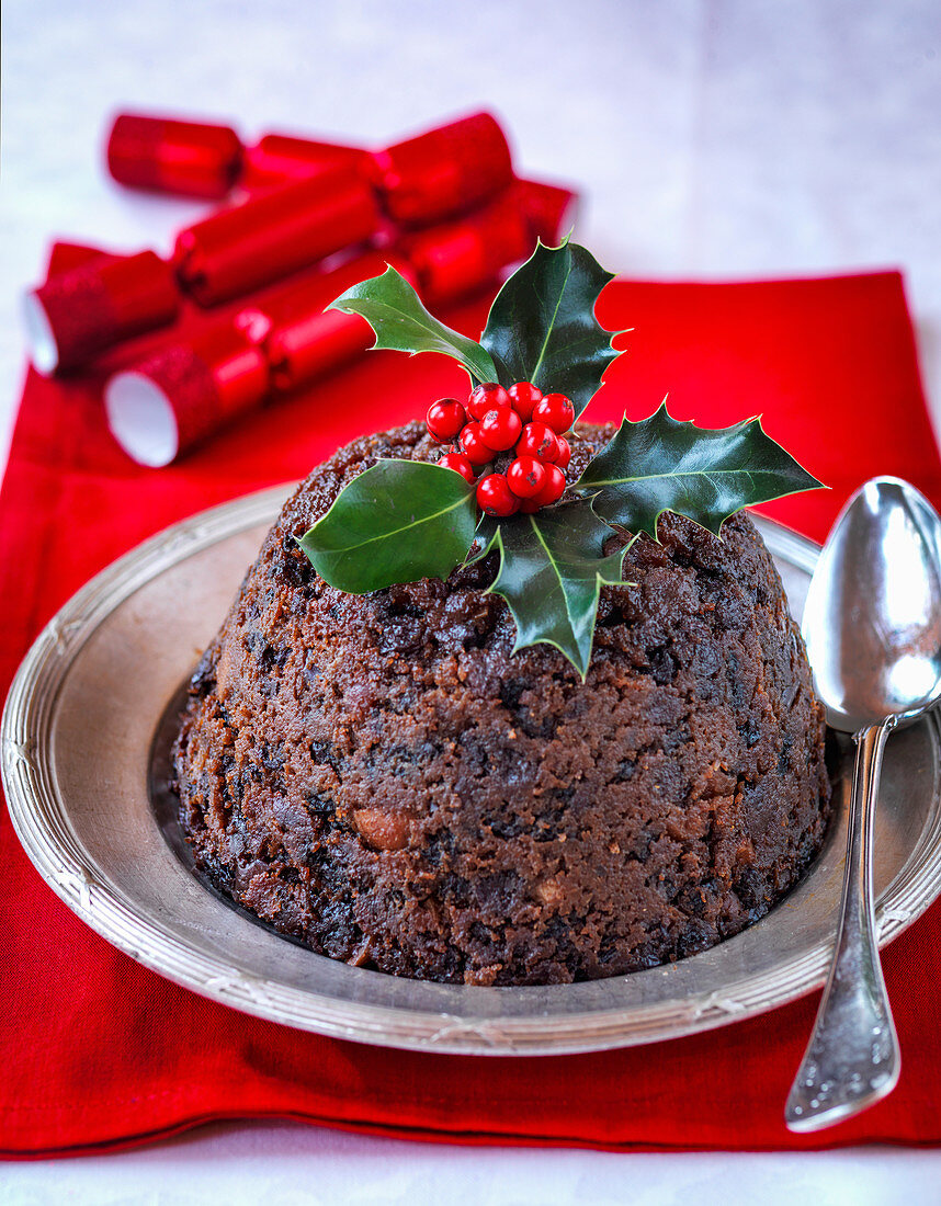 Englischer Christmas Pudding dekoriert mit Stechpalmenzweig
