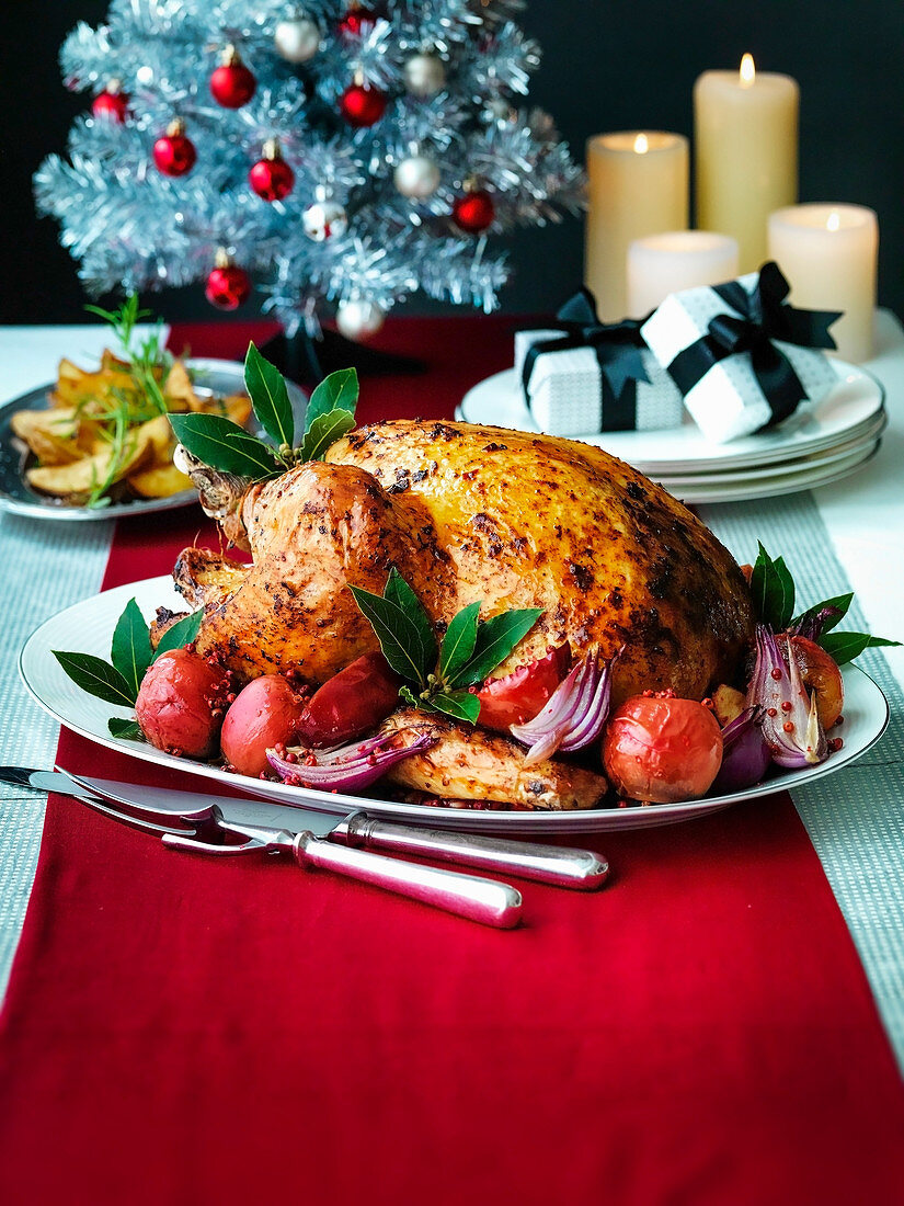 Christmas Turkey with roast red apples and onions with potato wedges and silver Christmas tree