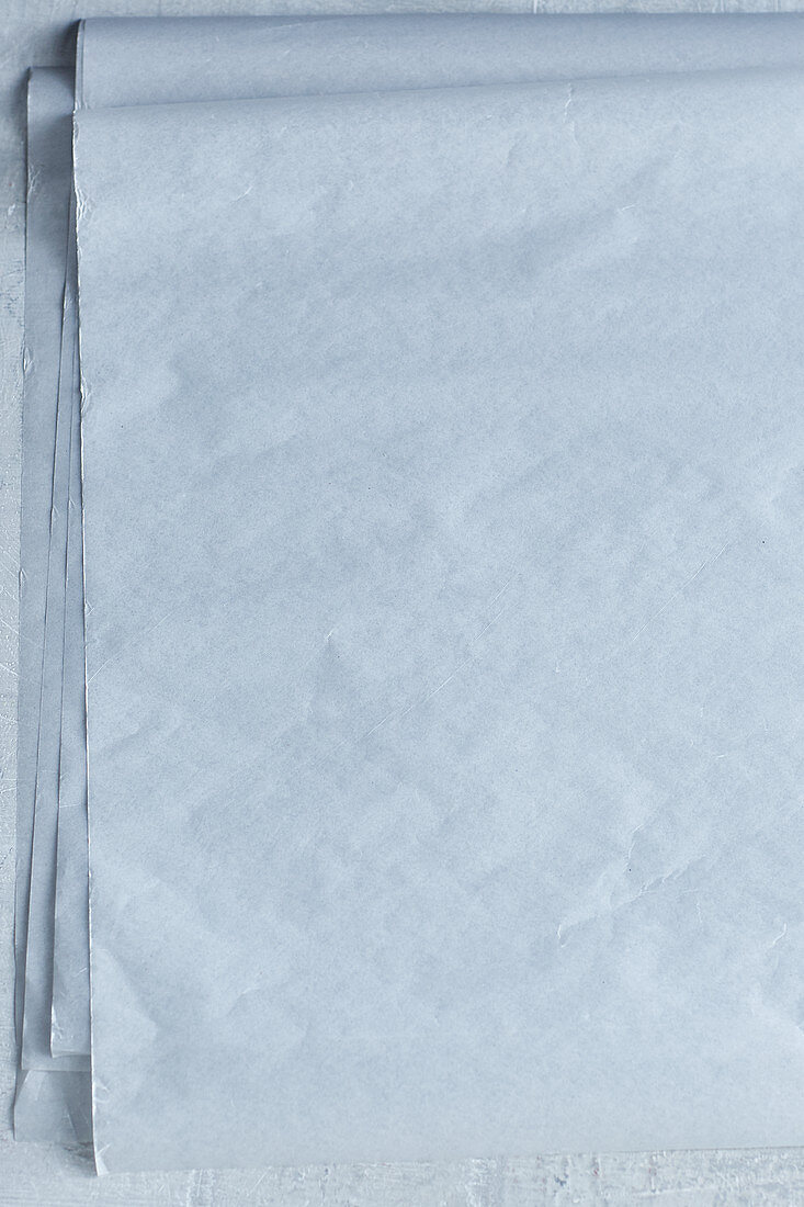 Multiple sheets of white parchment paper (seen from above)