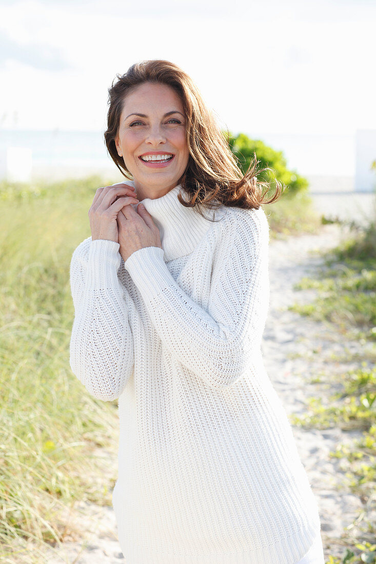 Brunette woman wearing white knit sweater