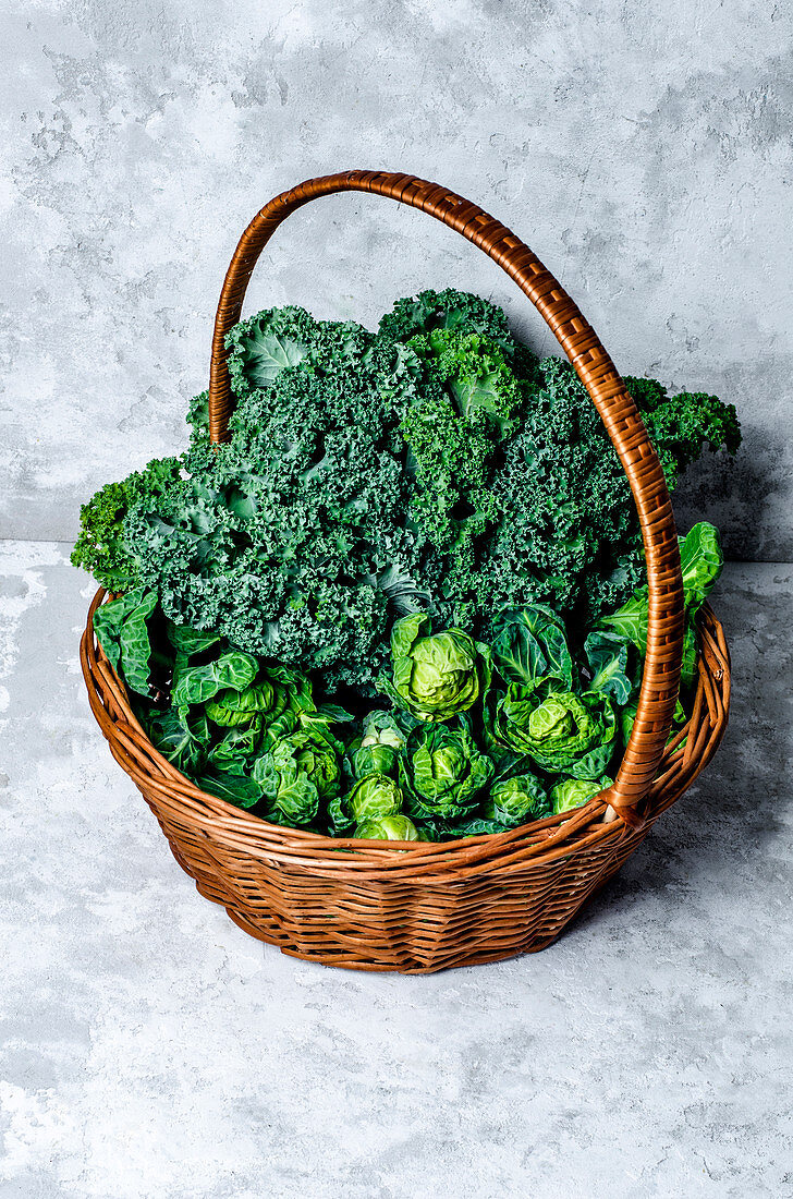 Fresh brussels sprouts and kale leaves in a basket