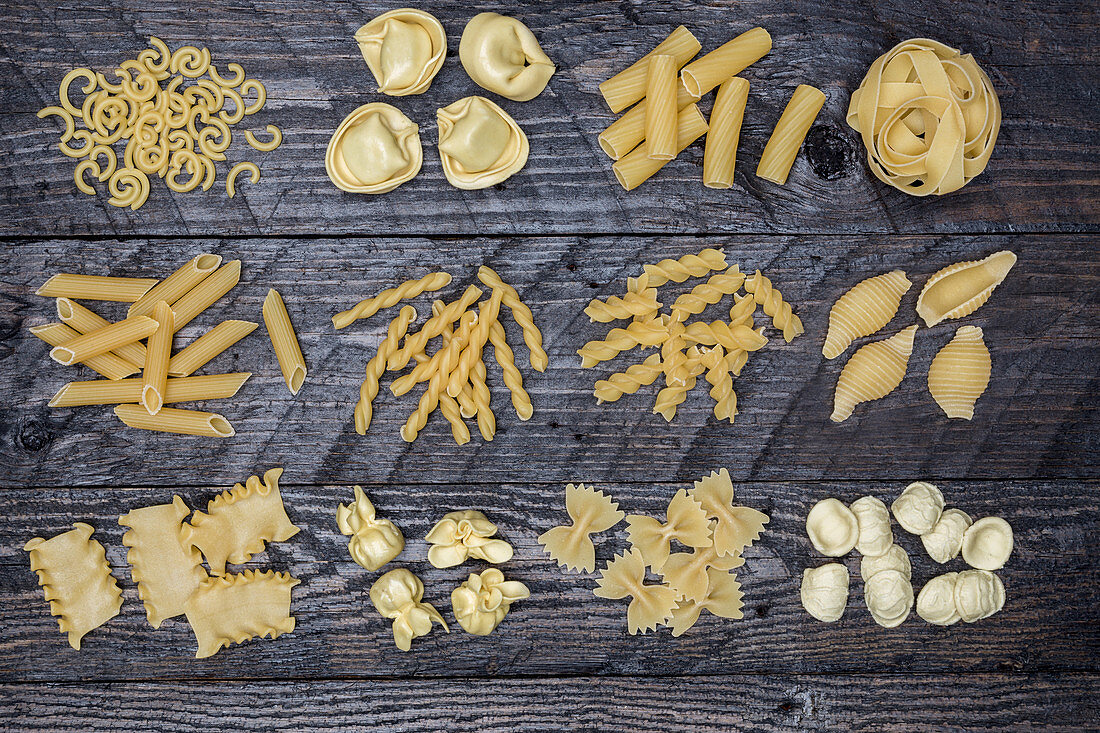 Various types of pasta on a wooden surface