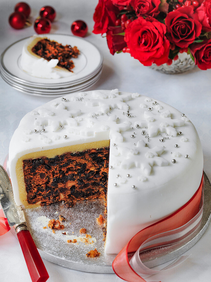 Classic Fondant Iced Christmas cake cut into with slice