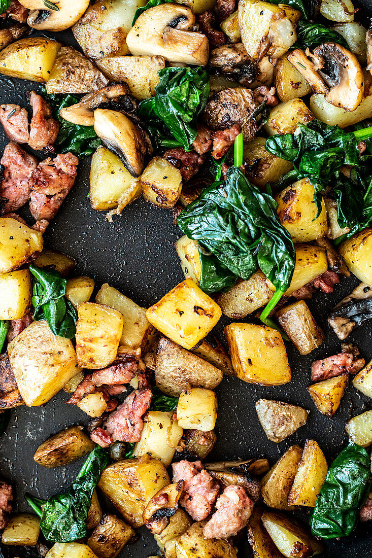 Fried potatoes with spinach and salsciccia, close up