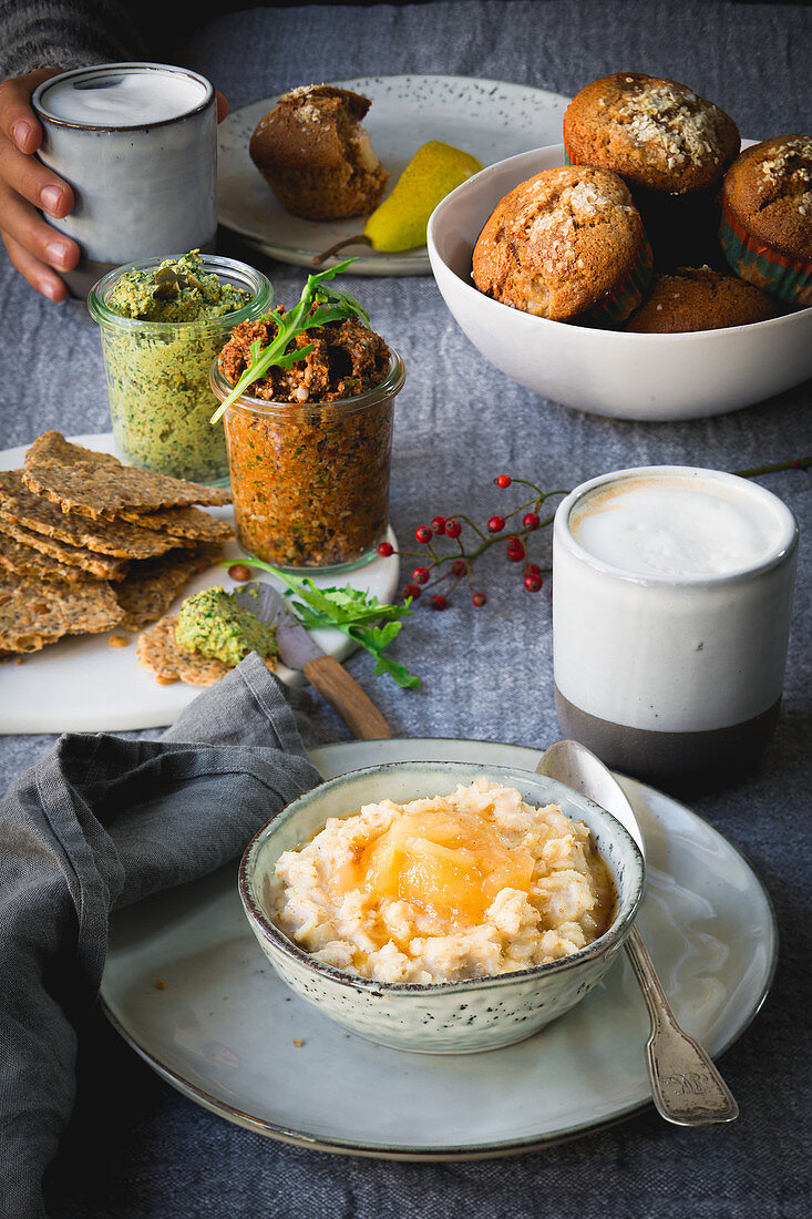 Porridge with pear compote, crackers, tomato and pumpkin dip, pear muffins and a latte for breakfast