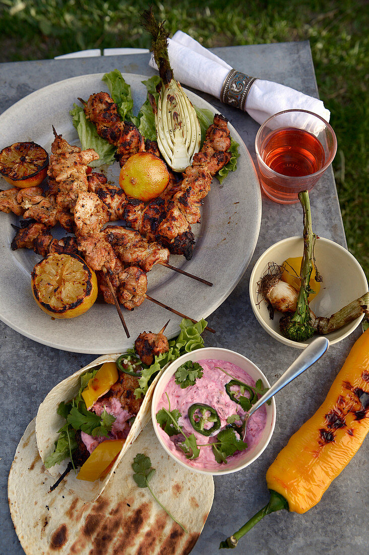 Grilled tandoori chicken skewers with a beetroot dip and lemons