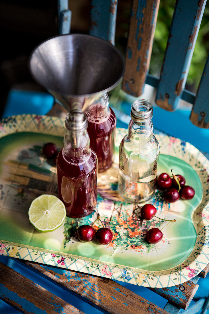 Kirschsaft mit Limette und Orange in Flaschen abfüllen