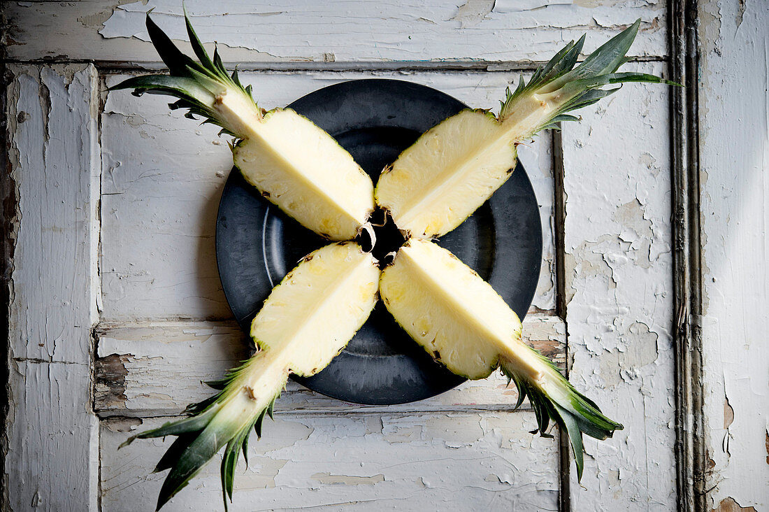 A quartered pineapple on a plate (seen from above)