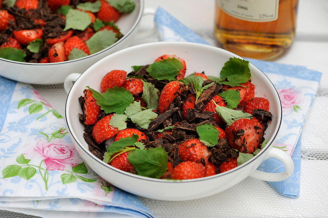 Erdbeeren mit geraspelter dunkler Schokolade und Zitronenmelisse
