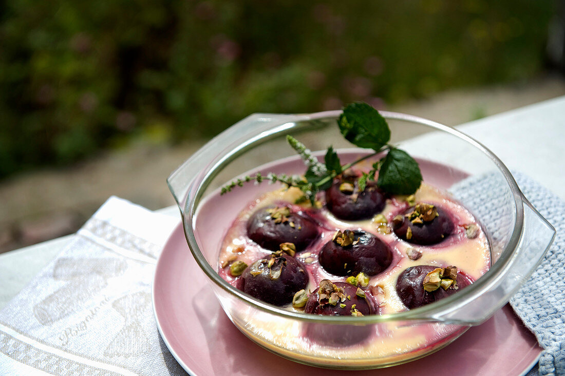 Gratinated plums filled with almonds and pistachios in vanilla sauce