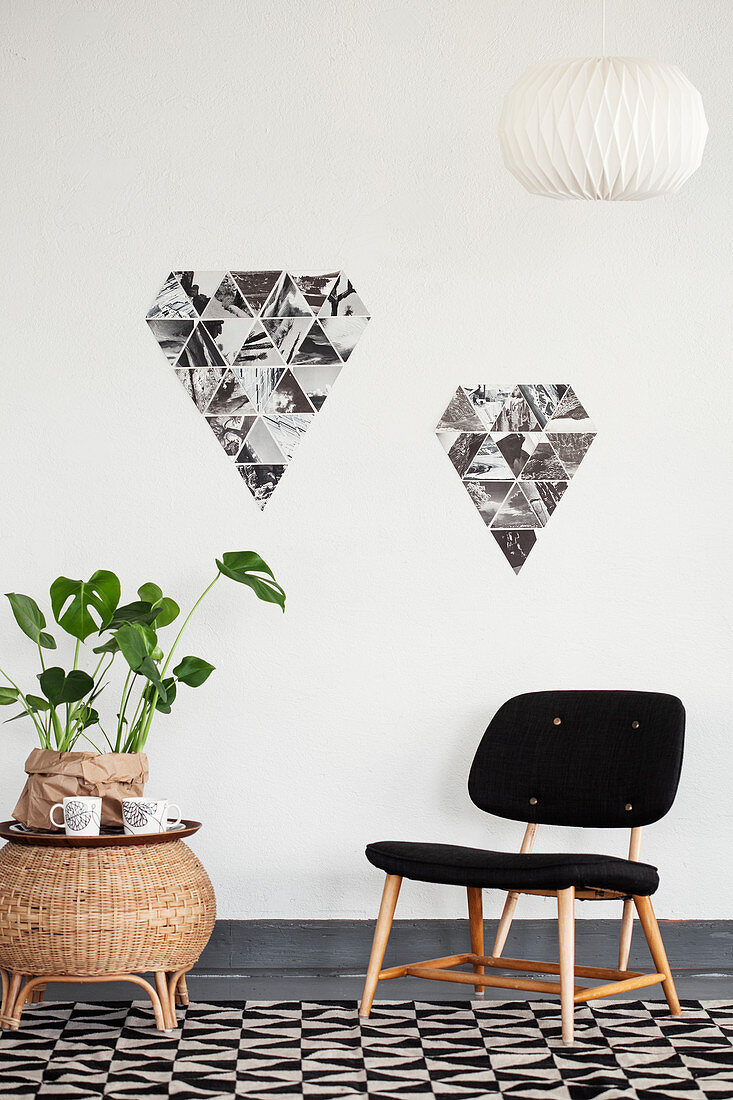 Chair, houseplant on side table and arrangement of black-and-white photos on wall