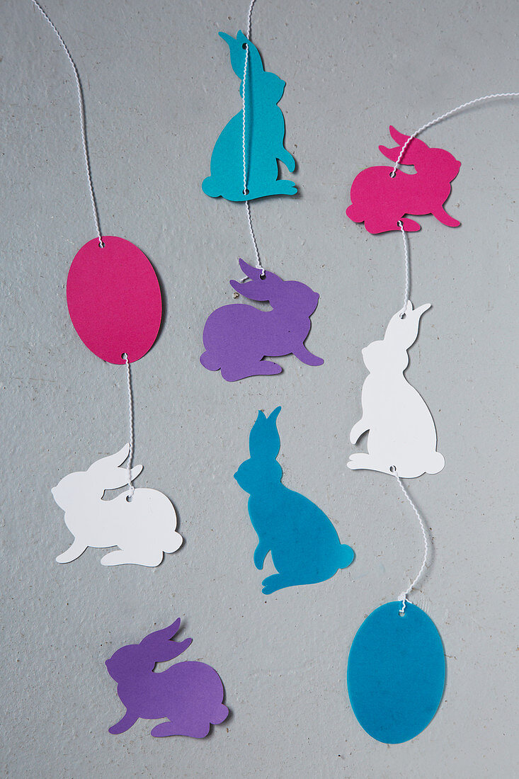 Strings of paper Easter eggs and Easter bunnies