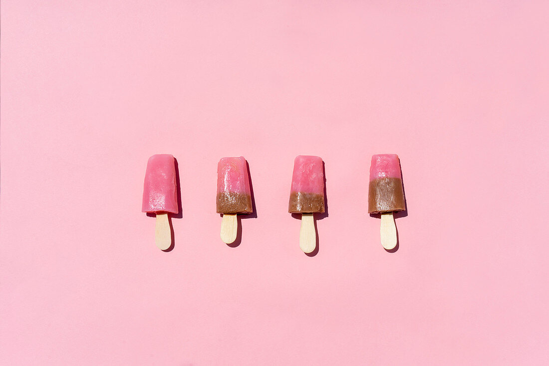 Bright popsicles placed on pink background