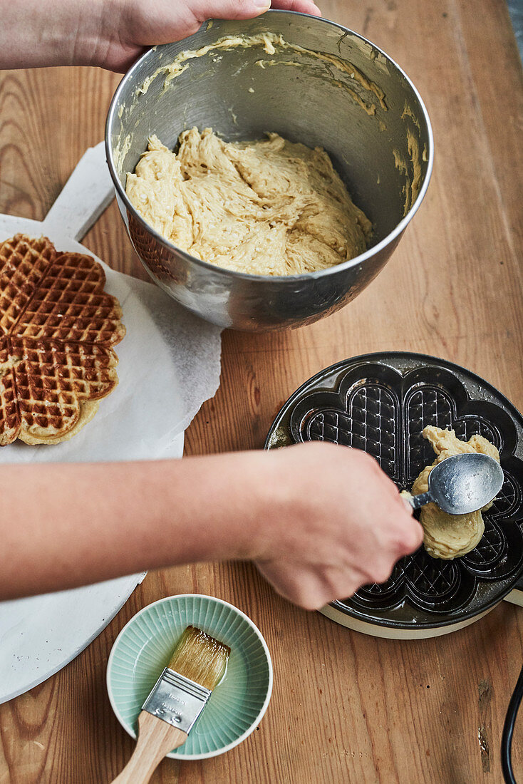 Waffle batter being placed in a waffle iron