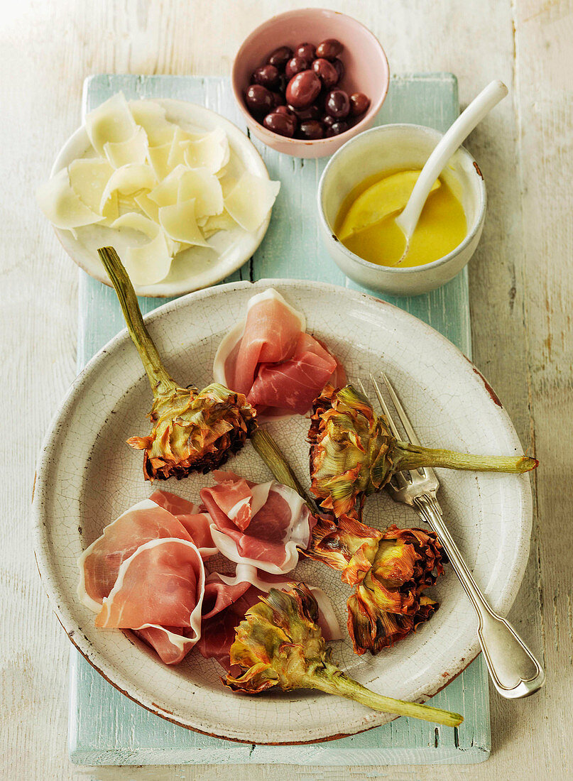 Artichokes and parma ham with parmesan cheese and black olives