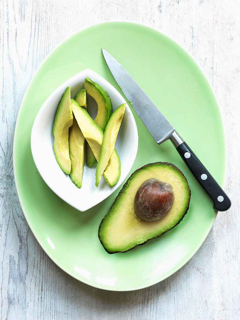 Half avocado with knife