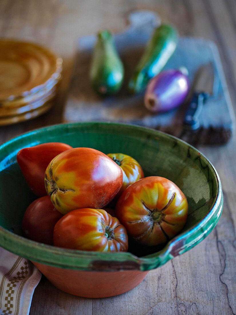 Large plum tomatos in a rustic bowl