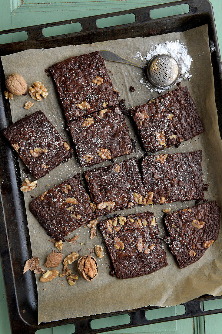 Brownies with walnuts on a baking tray (seen from above)