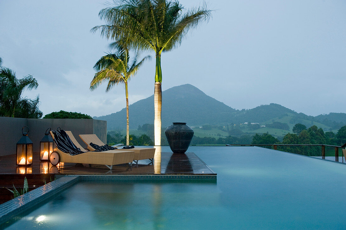 Two loungers next to pool at twilight