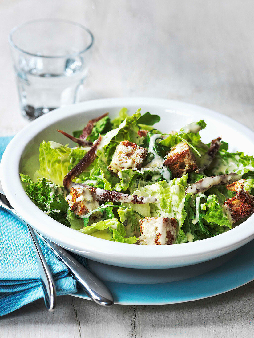 Caesar salad with Romaine lettuce rocket anchovies and croutons with a parmesan cheese dressing