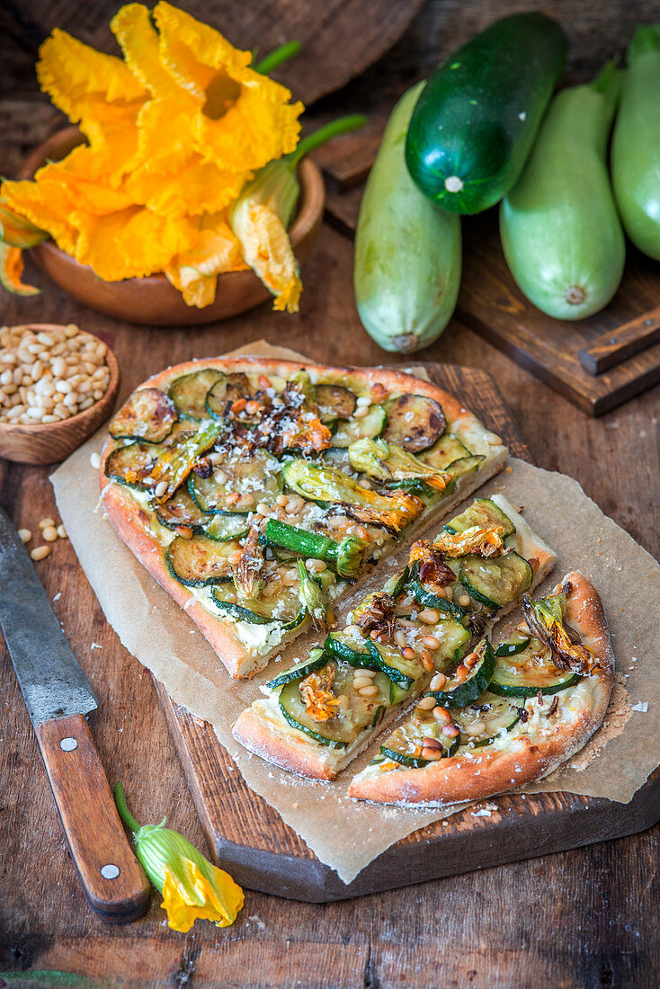 Pizza mit Zucchini, Zucchiniblüten und Pinienkernen