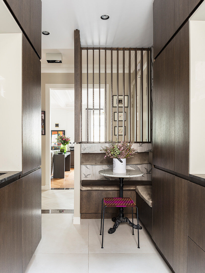 Corner bench and bistro table in kitchen with dark fitted furnishings